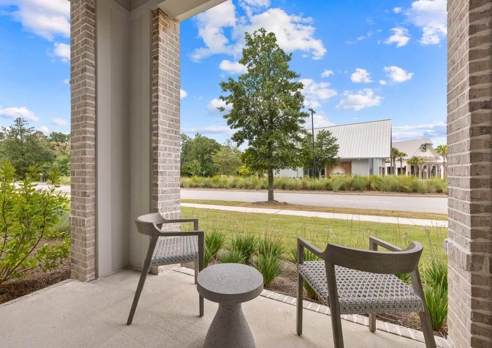 Model patio featuring chairs and a view of the community.